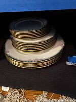 Stacked plates showing 6 small, 6 medium, and 5 large plates with floral design and gold trim edges.