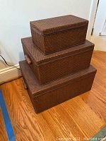 Photo of the three stacked brown woven storage cases showing exterior and size progression