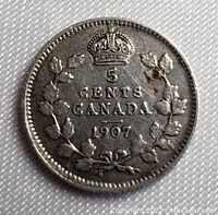 Reverse side showing denomination 5 cents, year 1907, Canadian maple leaf wreath, and crown.