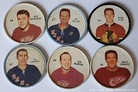 Front view of all six hockey trading coins featuring six different players from the 1960s NHL, displaying player portraits, jersey numbers, and team logos.