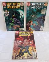 Three Batman Wildcat comic books, in protective sleeves, placed on a white surface with visible colorful cover artwork.