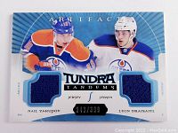 Front view of the limited edition Leon Draisaitl and Nail Yakupov dual jersey hockey card with two blue jersey swatches and player photos.
