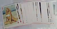Playing cards spread out showing images of female models in swimwear and lingerie posing on beach or outdoor settings, all cards clearly visible and in good condition.
