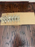 Top view of 7 brown clipboards stacked with metal clips aligned at the top center.