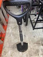 Full view of shovel standing upright showing handle, shaft, and blade