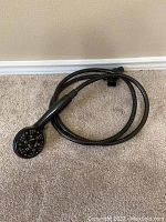 Single shower head attached to flexible hose with oiled rubbed dark finish.