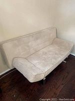 Tan microfiber futon sofa showing general condition and fabric texture
