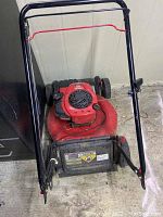 Photo of a red Troy-Bilt self-propelled lawn mower with black handle and wheels showing condition and overall appearance.
