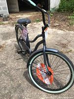Full view of the Huffy Cranbrook cruiser bike showing the frame shape, black color with light blue rims, and overall condition.