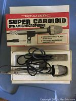 Photo of the Realistic Super Cardioid Dynamic Microphone 33-992 in its original box with attached cable and plug.