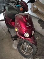 Front view of red E-Ton Beamer scooter showing dual headlamps, E-Ton logo on front fairing and front wheel