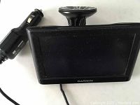 Garmin nüvi 55 GPS device with attached suction mount and car charger cable placed on a white surface.