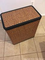 Front angled view of a large rectangular laundry hamper with a dark trim lid and woven basket pattern.