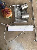 Photo showing ceramic rooster cookie jar, fluorescent light fixture with power cord, IKEA metal rack with steel containers