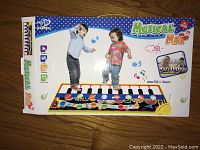 Kids Musical Mat box depicting two toddlers playing on a piano keyboard style musical mat 110x36cm size