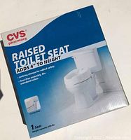 Photo of boxed CVS branded raised toilet seat showing product details and packaging