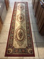 Full view of the runner rug laid out on tile floor showing its length and pattern