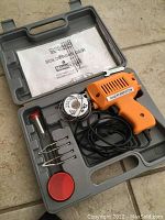 Chicago Electric soldering gun kit in gray molded plastic case with solder wire spool, soldering tips, and manual