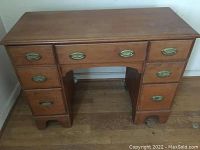 Overall view of vintage wooden pedestal desk showing all drawers and surface condition.