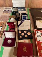 Overview of table with multiple Royal Canadian Mint sets, coins and penny rolls