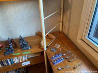 View of the carved wildlife pieces, bookends, and toy cars on a wooden shelf and table corner.