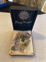 Open blue velvet-lined box marked 'Lady Harris' containing a linked silver charm bracelet with various charms inside