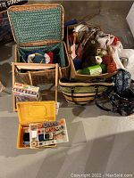 Basket and tote filled with yarn, sewing threads in plastic organizer, and boxed wooden blocks