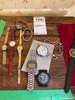 Multiple vintage watches arranged on a wooden surface showing different styles and bands