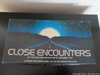 Box top showing artwork with road approaching bright light in starry sky, labeled 'Close Encounters of the Third Kind, A Parker Brothers Game'