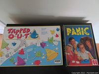 Photo of two vintage board game boxes side by side: Tapped Out by Irwin with colorful cartoon cones on the cover, and Panic by Jumbo featuring people playing the game.