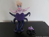 Full view of the 12-inch Ursula doll standing with six tentacles spread out, and the smaller 3 3/4-inch vinyl Ursula figurine in front sitting down.