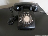 Front angle view of the black Northern Telecom G Type rotary phone showing the dial and handset.