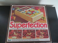 Box cover showing title Superfection, images of people playing the game and sample puzzle layout