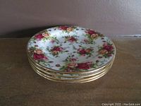 Stack of 4 Royal Albert Old Country Roses plates showing floral pattern and gold trimmed scalloped edges.