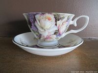 Close-up of the Royal Elfreda teacup resting on the saucer showing the detailed floral design and gold rim.