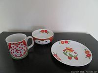Photo of the three stacking pieces: mug, bowl, and plate decorated with strawberry girl theme.