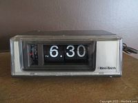 Front view of vintage Ken-Tech flip clock showing time 6:30 PM on large numeric flipping cards and side alarm dial.