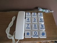 Photo of the white Webcor big push button phone from a top angle showing all large buttons clearly.