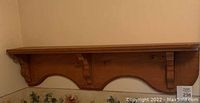 Full view of the antique maple wood corner shelf mounted on wall showing length and scalloped design underneath.