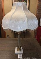 Full view of the lamp with shade showing overall design and height on table