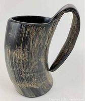Side view of large polished water buffalo horn tankard mug showing textured natural horn grain and curved handle.
