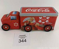 Front and side view of red vintage Coca Cola tin metal truck featuring Santa Claus graphics, showing overall condition and measuring approximately 10 inches long.