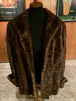 Front view of dark brown genuine mink jacket displayed on a mannequin, showing plush texture and shawl collar worn down.