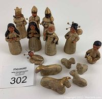 Complete set of 14 pieces displayed on white background, showing multiple human figures and animals with some missing hands and gold paint wear.