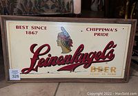 Front view of the wooden Leinenkugel's beer sign with logo, Native American Indian graphic, and text 'Best Since 1867', 'Chippewa's Pride', 'Beer Good as Gold'. Framed and lightly worn.