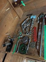 All assorted metal and plastic car accessories and emblems on wooden surface.