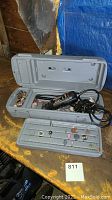 Dremel rotary tool with case open showing multiple grinding and sanding attachments.