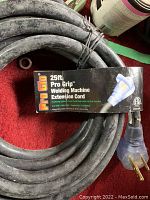 Coiled black 25ft Pro Grip welding machine extension cord with label showing product features and length.