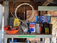 Overview photo of the lot on shelf showing all items including lightbulbs, masks, gloves, tape measures, cleaning towels, Christmas lights.