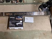 Overview of projector box, projector screen box, and accessories box arranged on a floor surface
